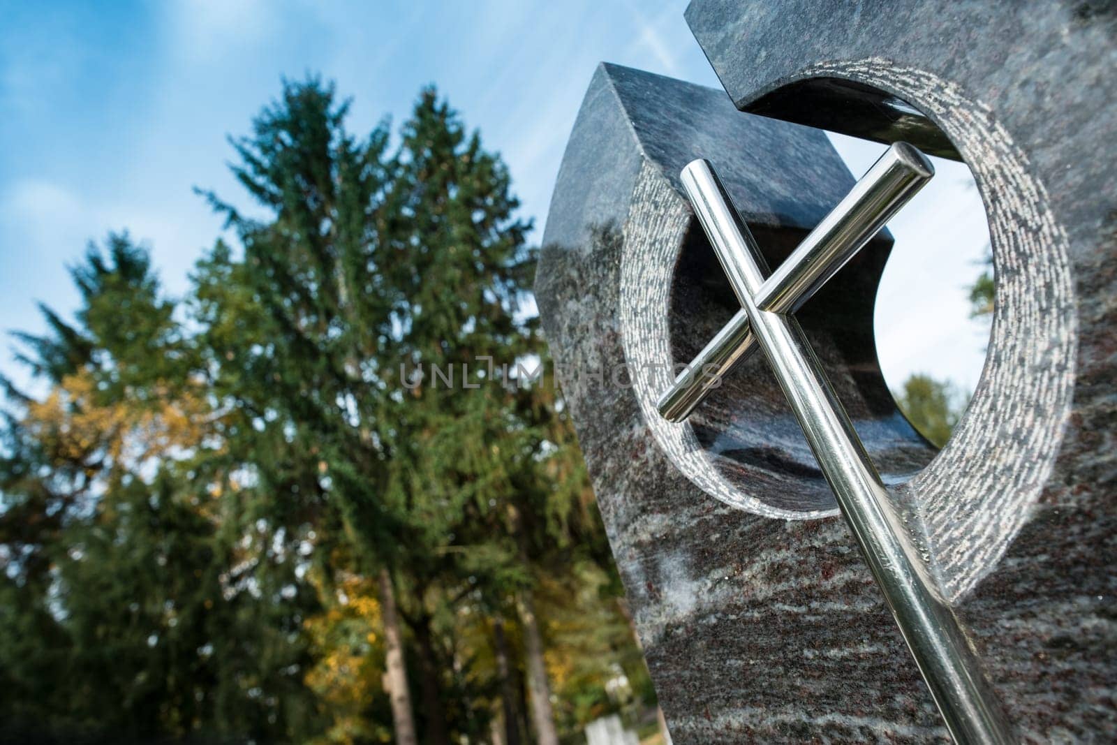 Cross and tombstone with trees in a cemetery