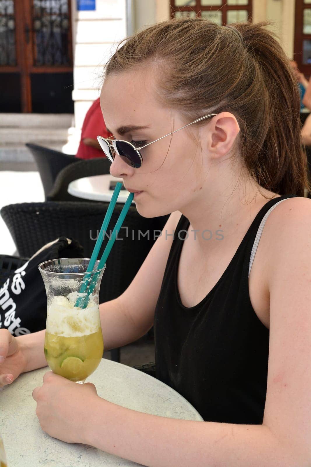 a teenager at the resort in Croatia drinks a non-alcoholic cocktail