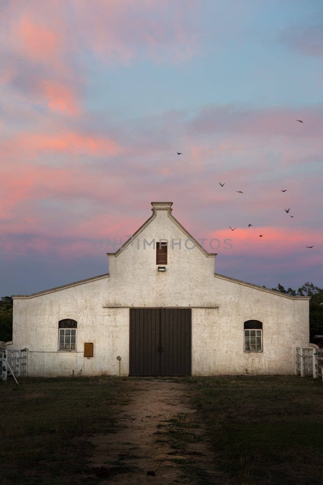 Large horse stables inspired by traditional Dutch architecture taken at sunrise.