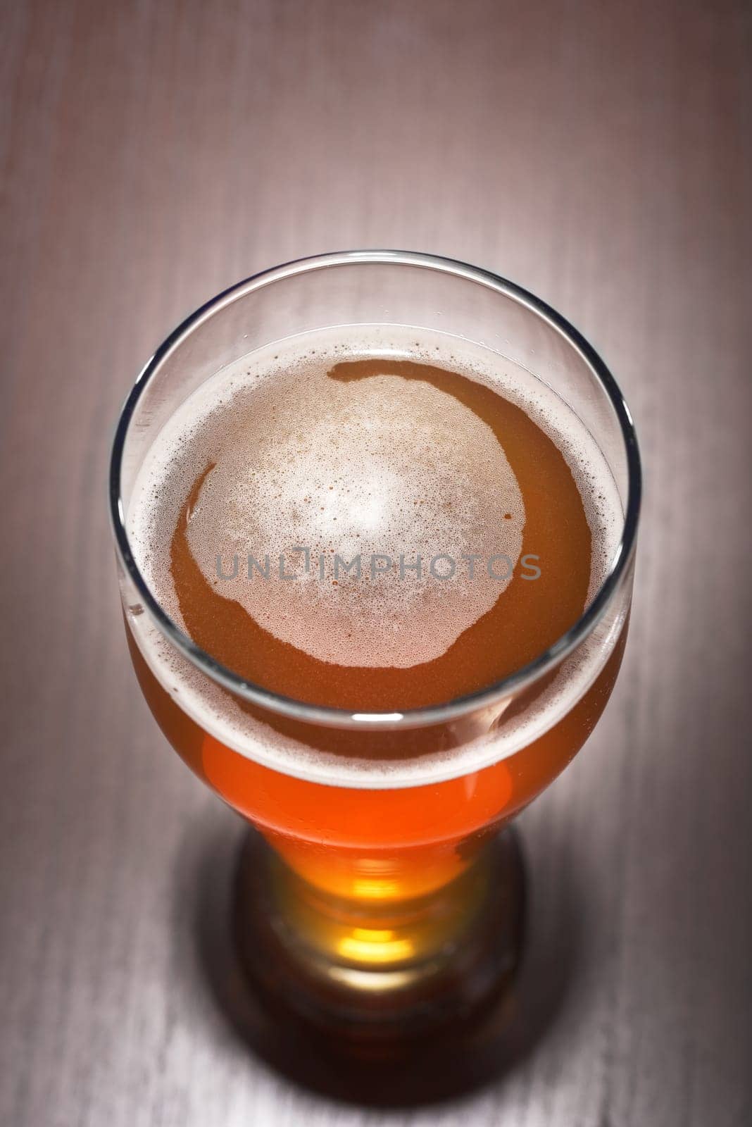 Close-up of a beer glass with foam on the table
