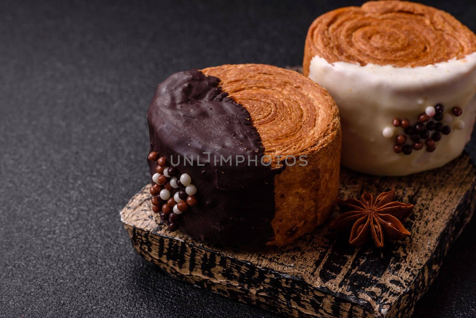 Round sweet New York roll croissant with chocolate cream filling on a dark concrete background