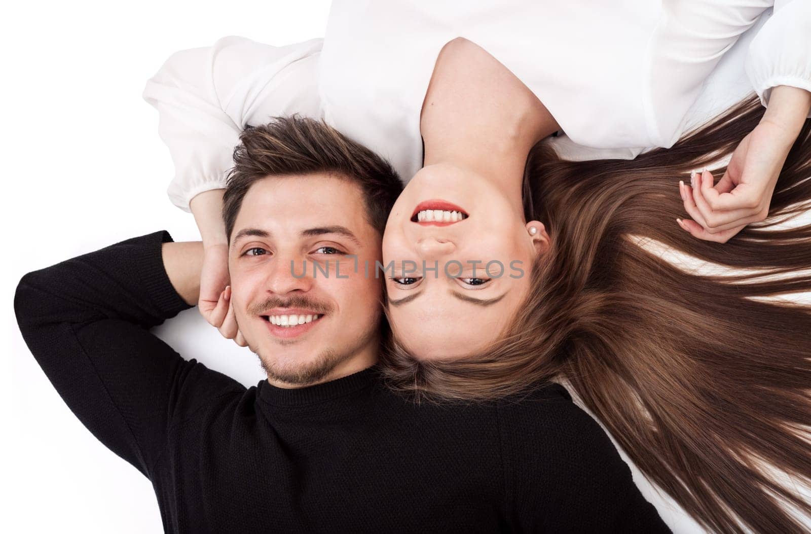 Happy young couple lying down on their back together