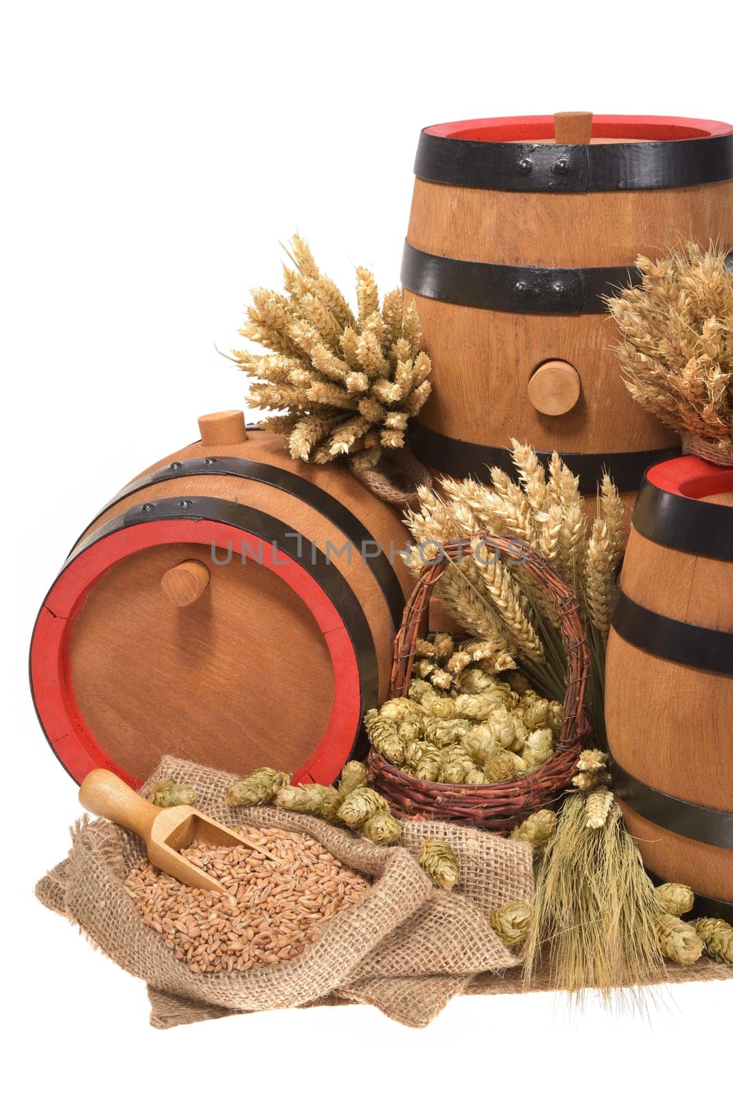 three old beer barrels insulated with wheat,barley,hops and malt On White