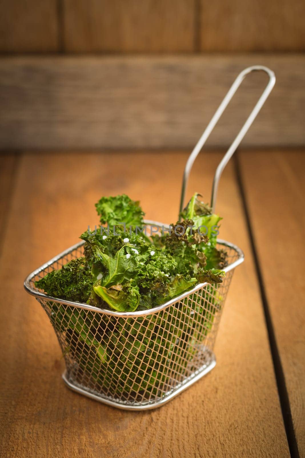 Kale chips with sea salt in a miniature fryer basket