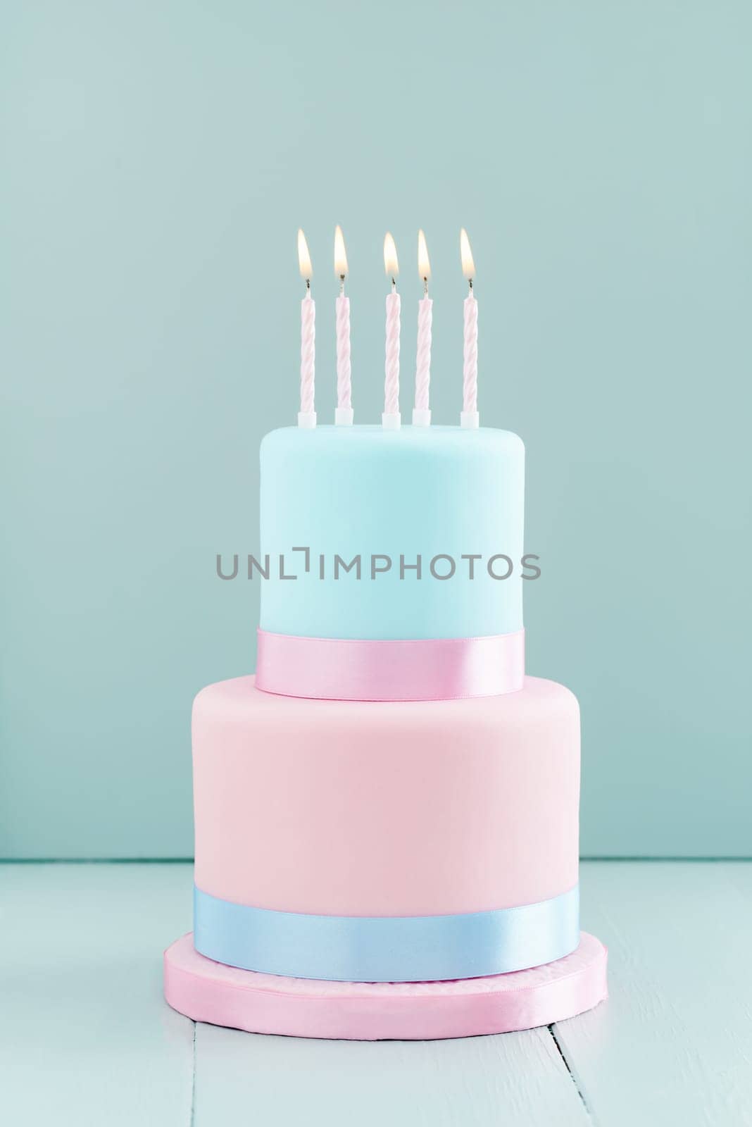 Fondant covered pastels coloured birthday cake with five birthday candles
