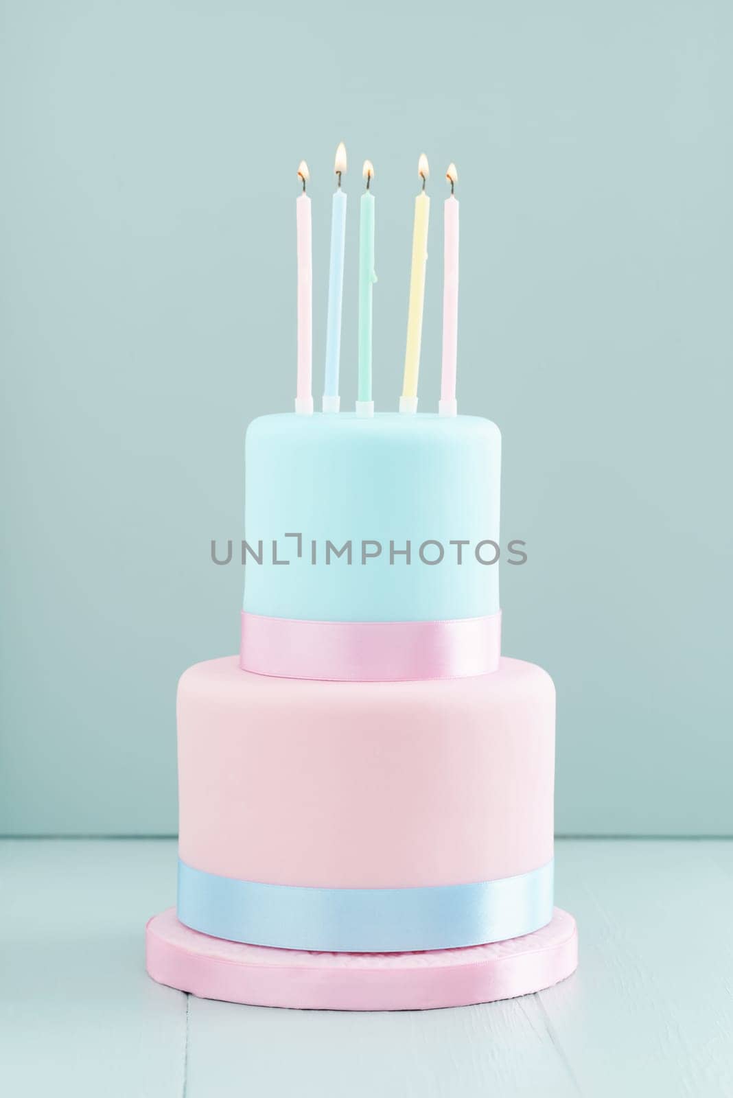 Fondant covered pastels coloured birthday cake with five birthday candles