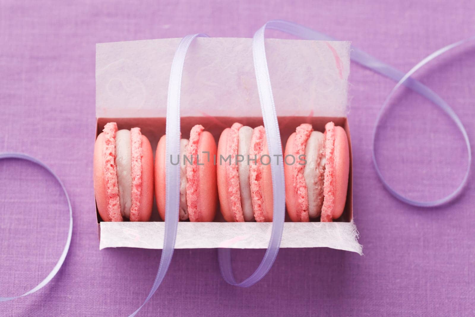 Pink macarons with buttercream filling in a box