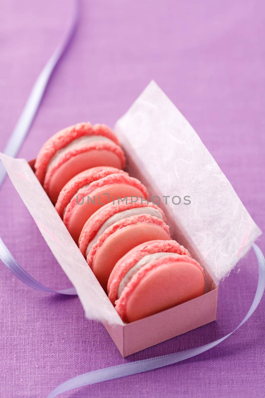 Pink macarons with buttercream filling in a box