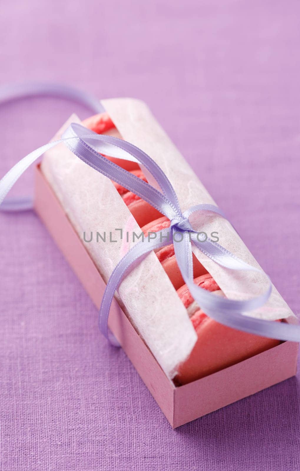 Pink macarons with buttercream filling in a box