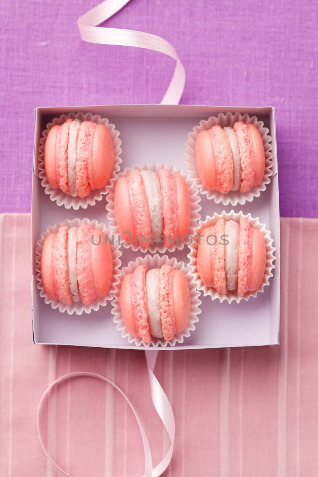 Pink macarons with buttercream filling in a box
