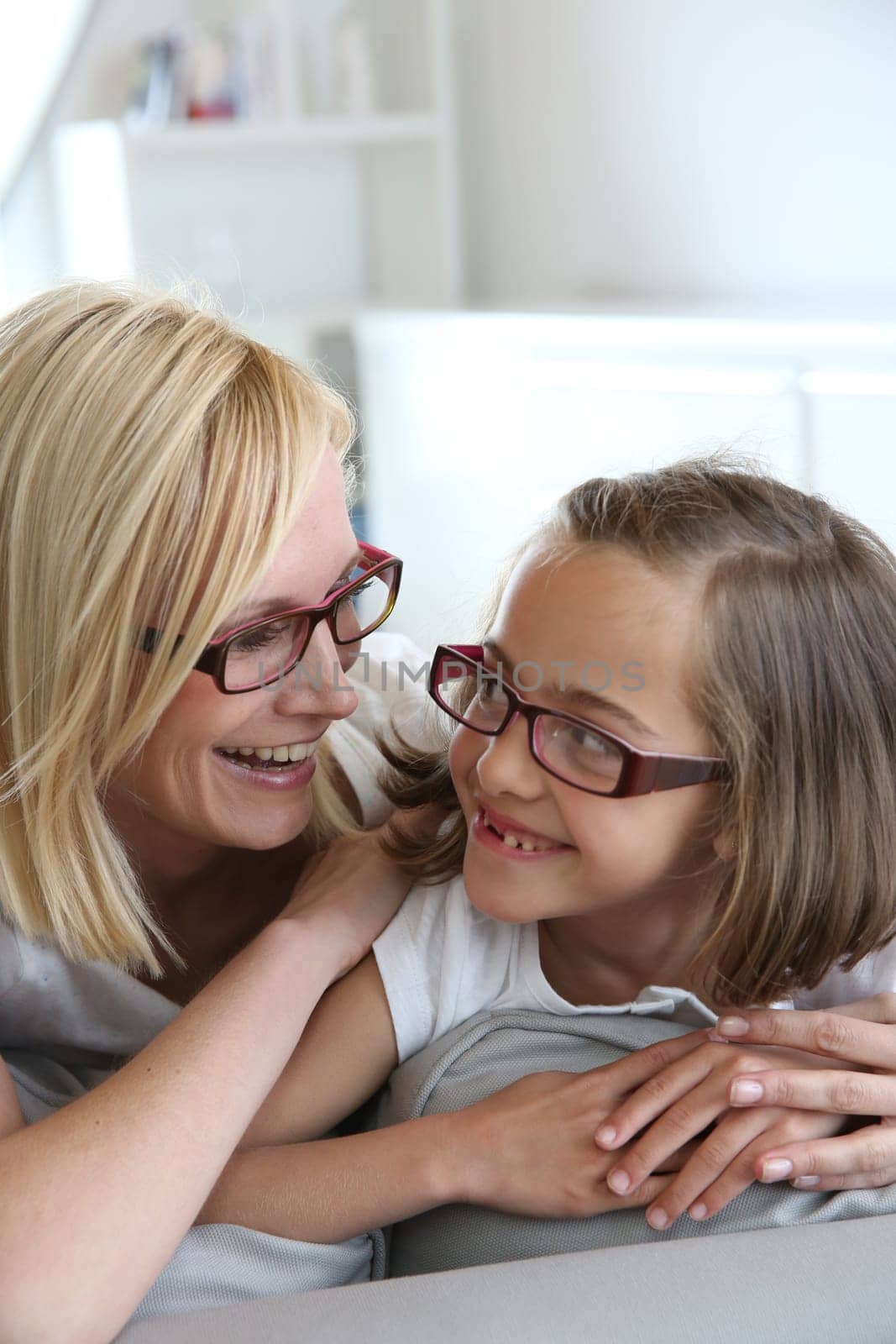 Mom and little girl sitting in sofa