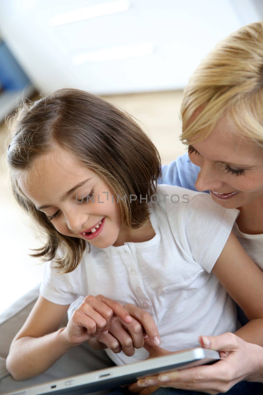 Mother and daughter playing with electronic tablet