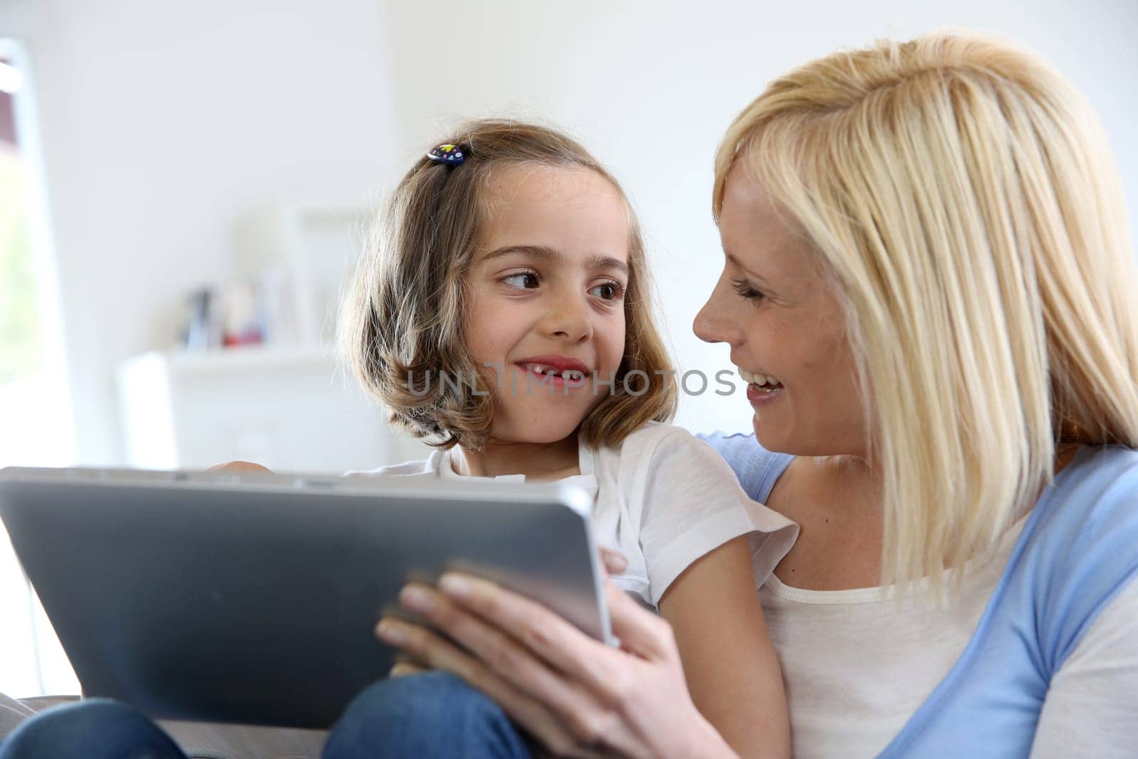 Mother and daughter playing with electronic tablet