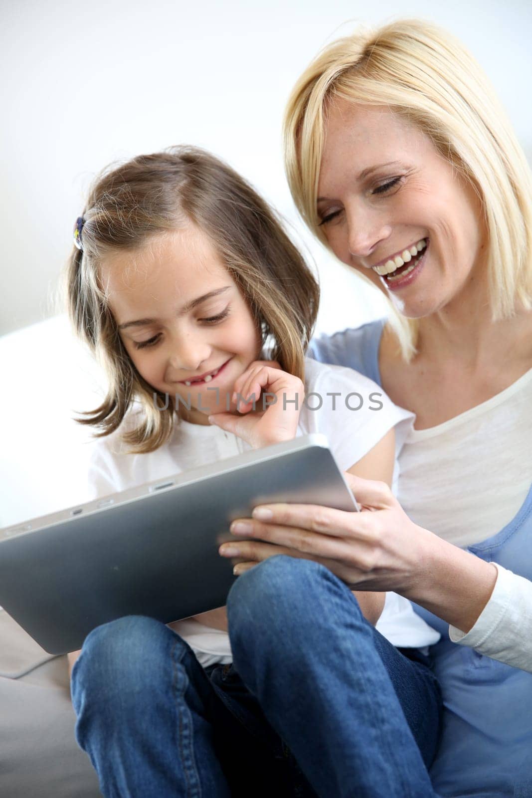 Mother and daughter playing with electronic tablet