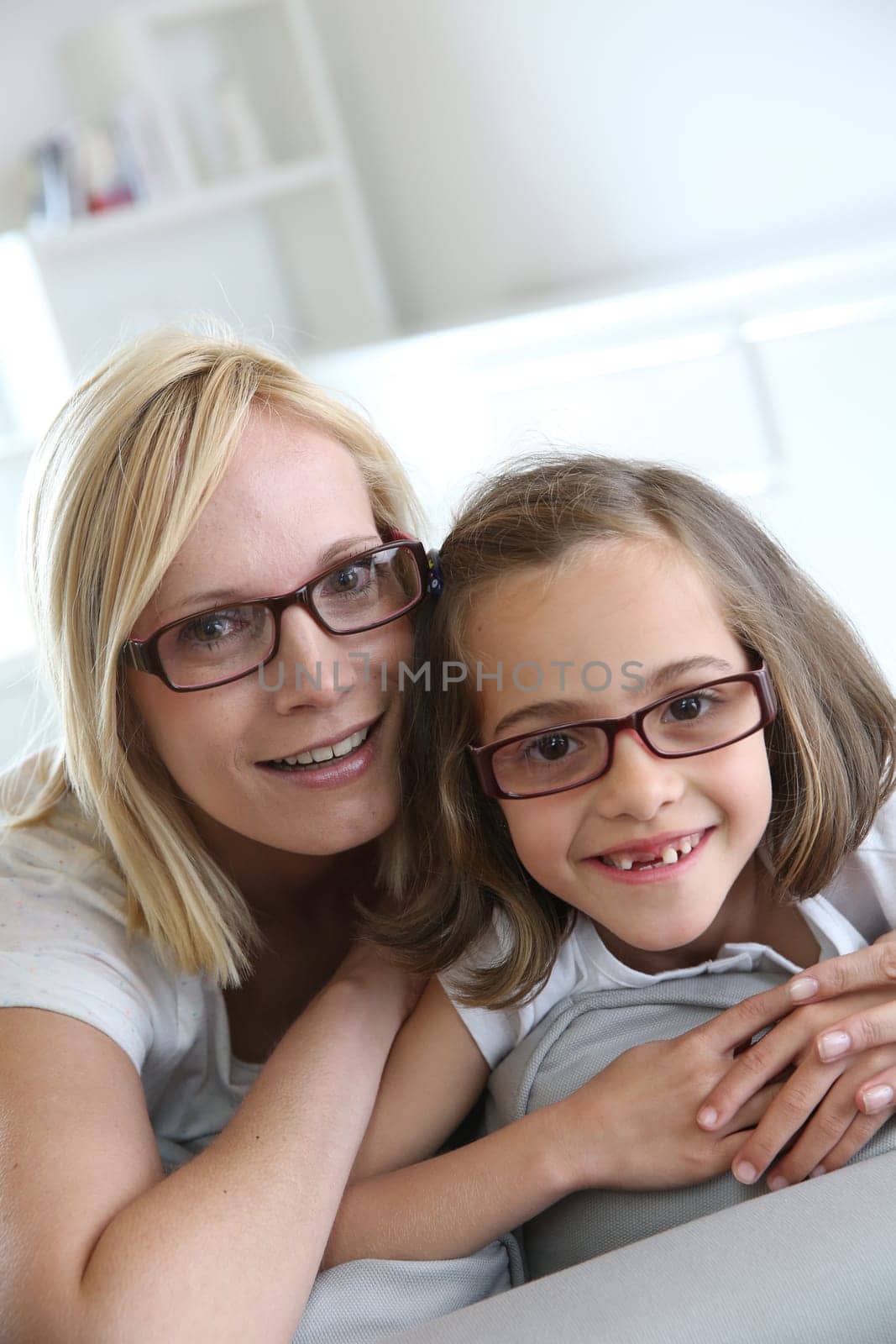 Mom and little girl sitting in sofa