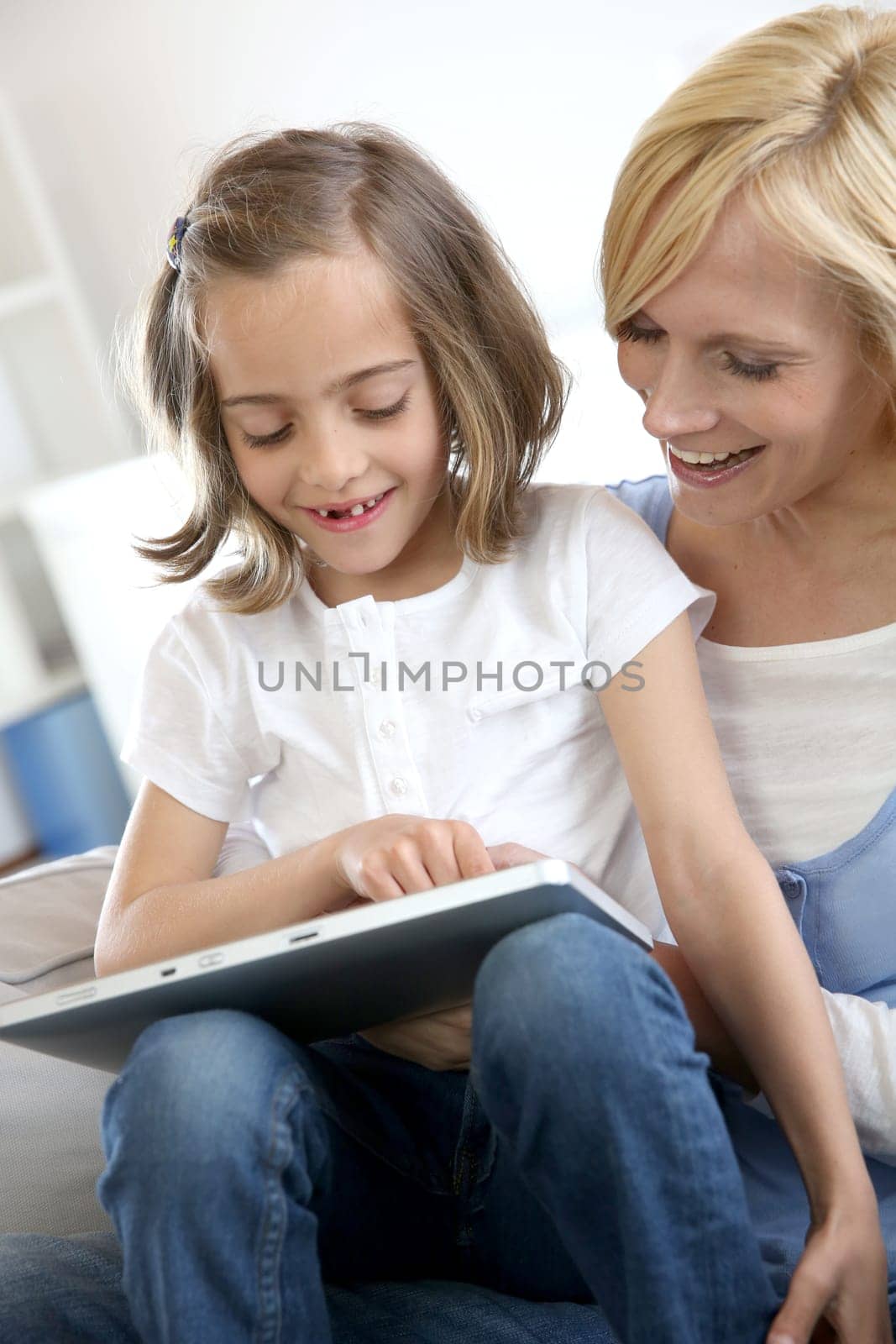 Mother and daughter playing with electronic tablet