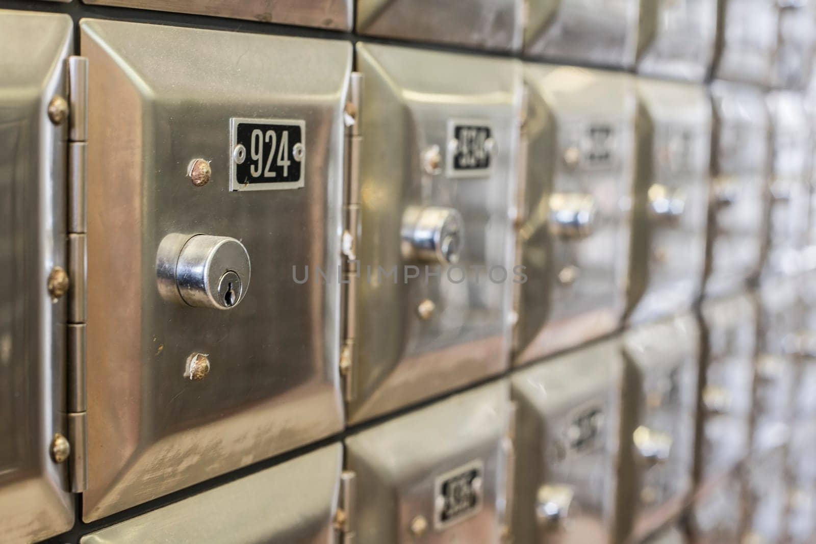 Many po boxes at the post office. The mail boxes are lined up in rows and columns. Selective focus