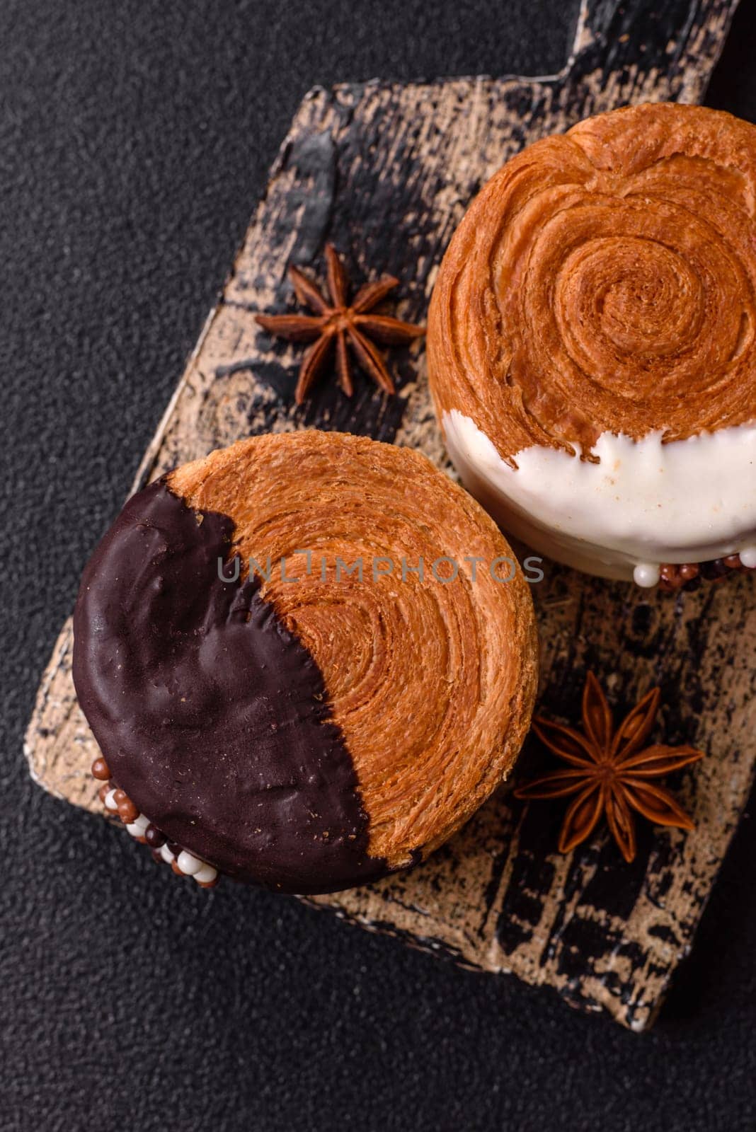 Round sweet New York roll croissant with chocolate cream filling on a dark concrete background