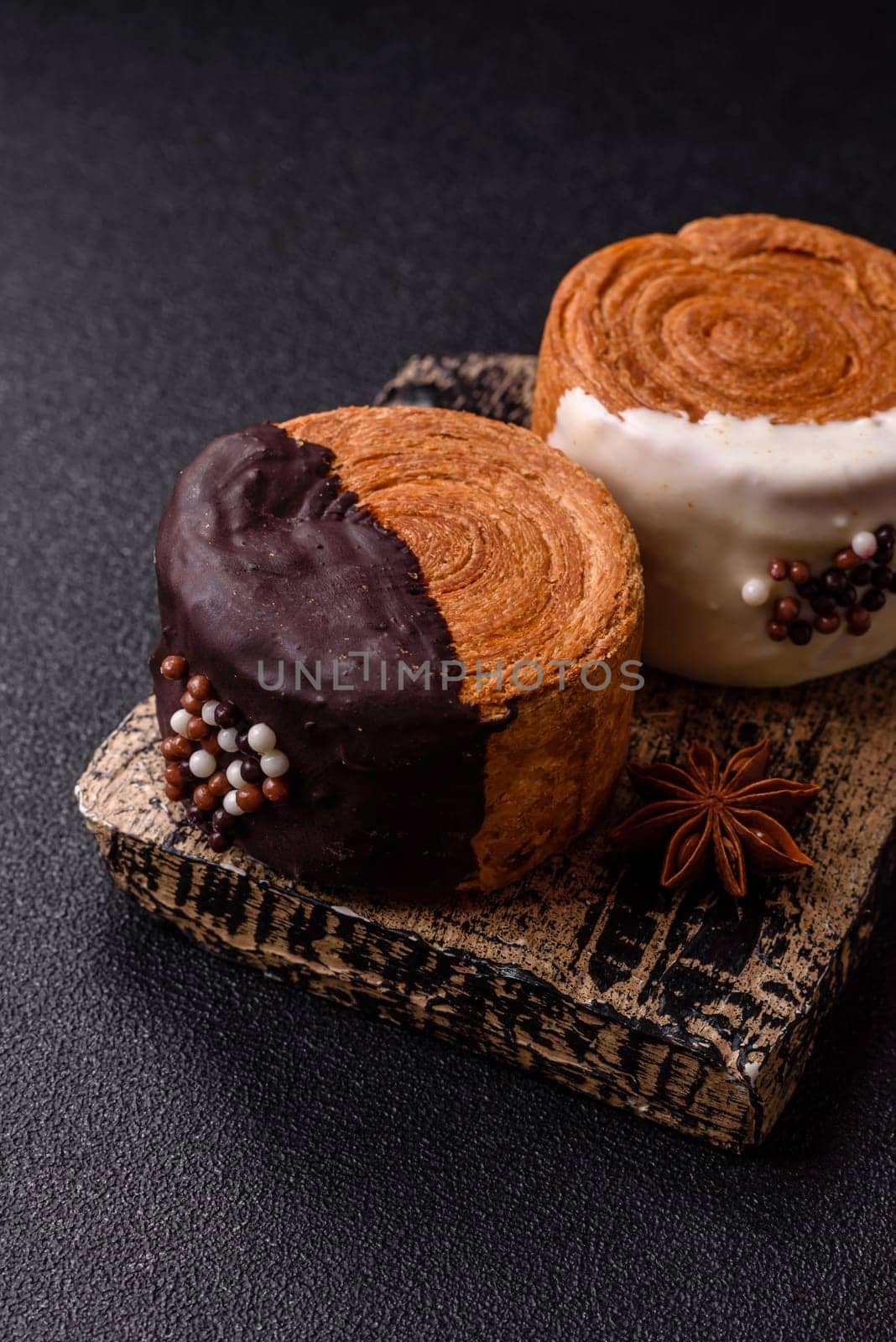 Round sweet New York roll croissant with chocolate cream filling on a dark concrete background