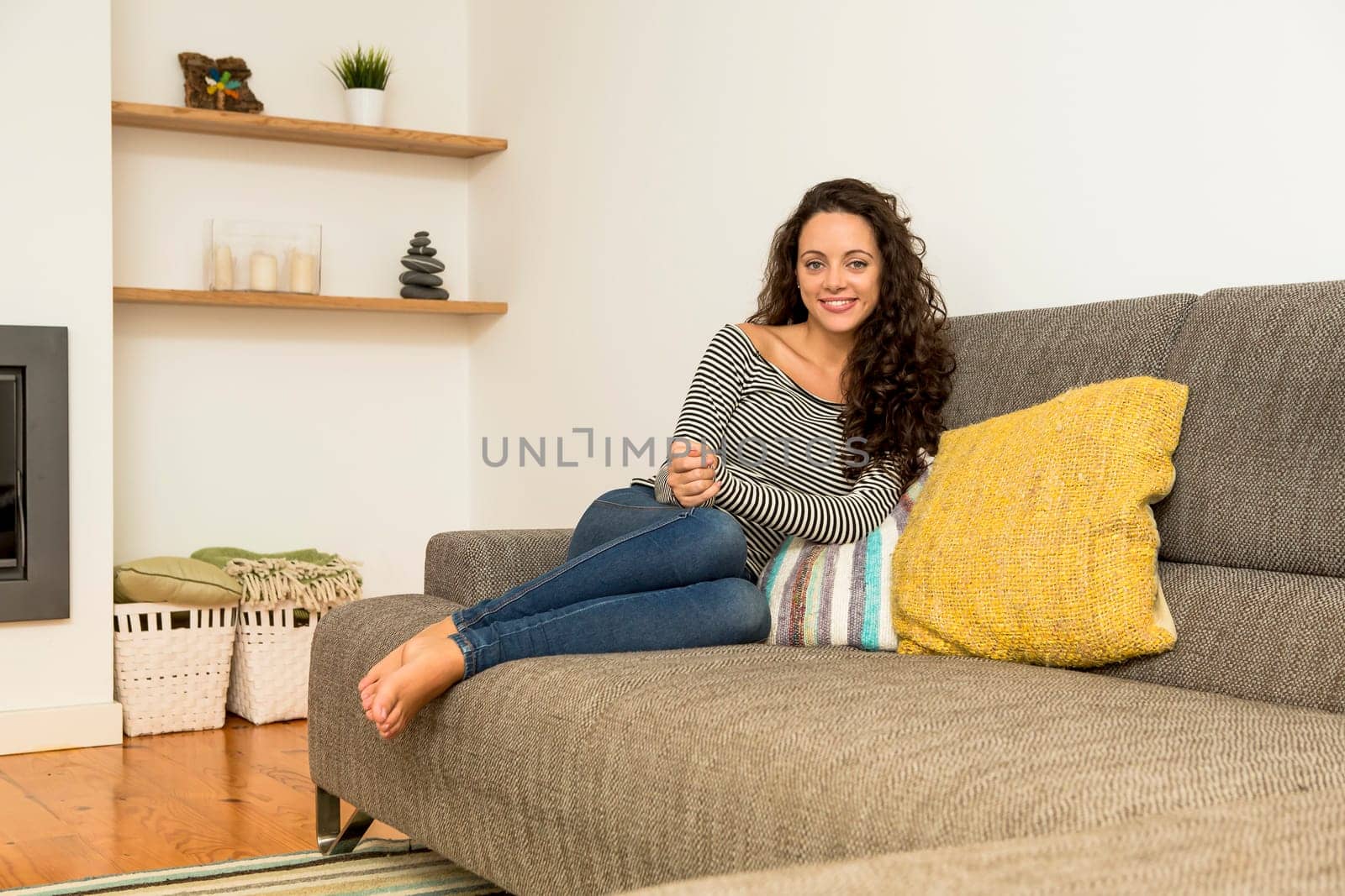 Beautiful woman drinking a hot tea at the warmth of the fireplace