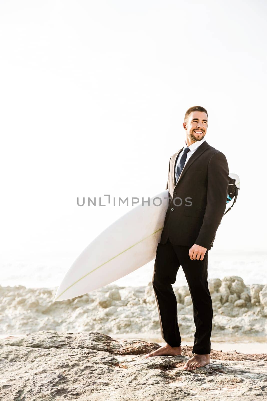 A Businessman holding is surfboard after a long day of work