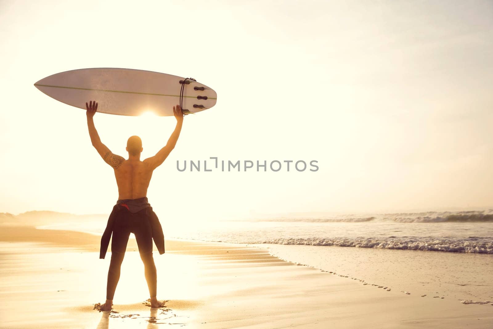 A surfer with his surfboard at the beach