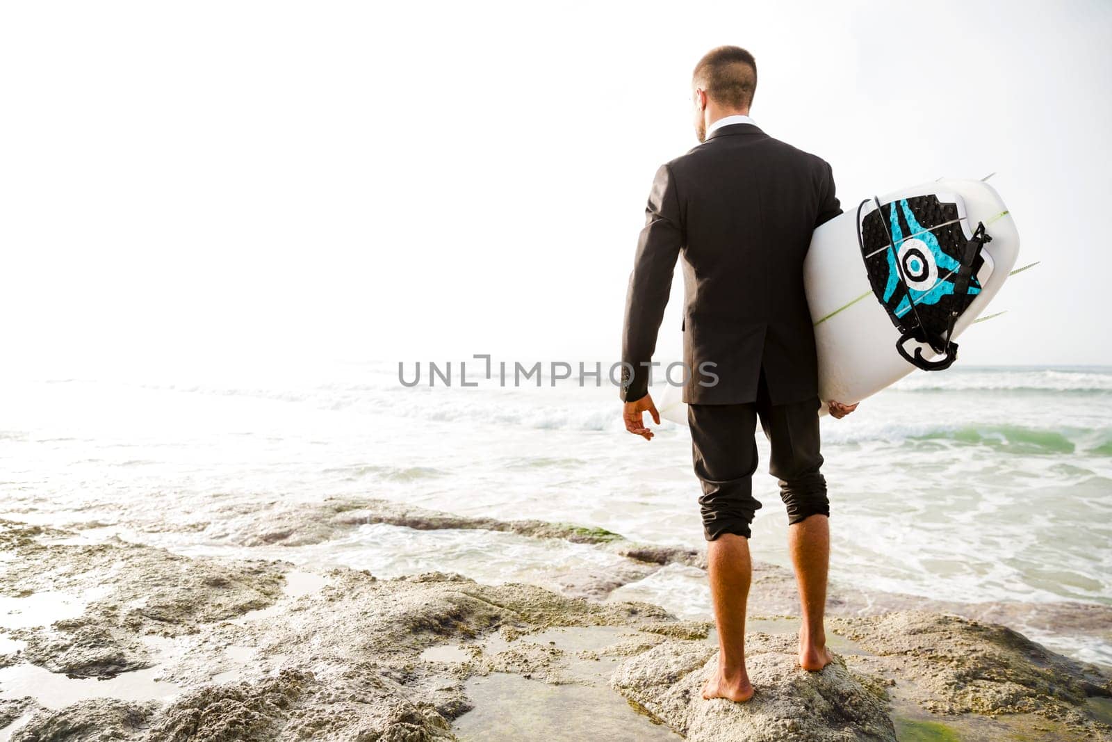 Businessman holding a chalkboard and is surfboard. Concept about a man starting a new life.
