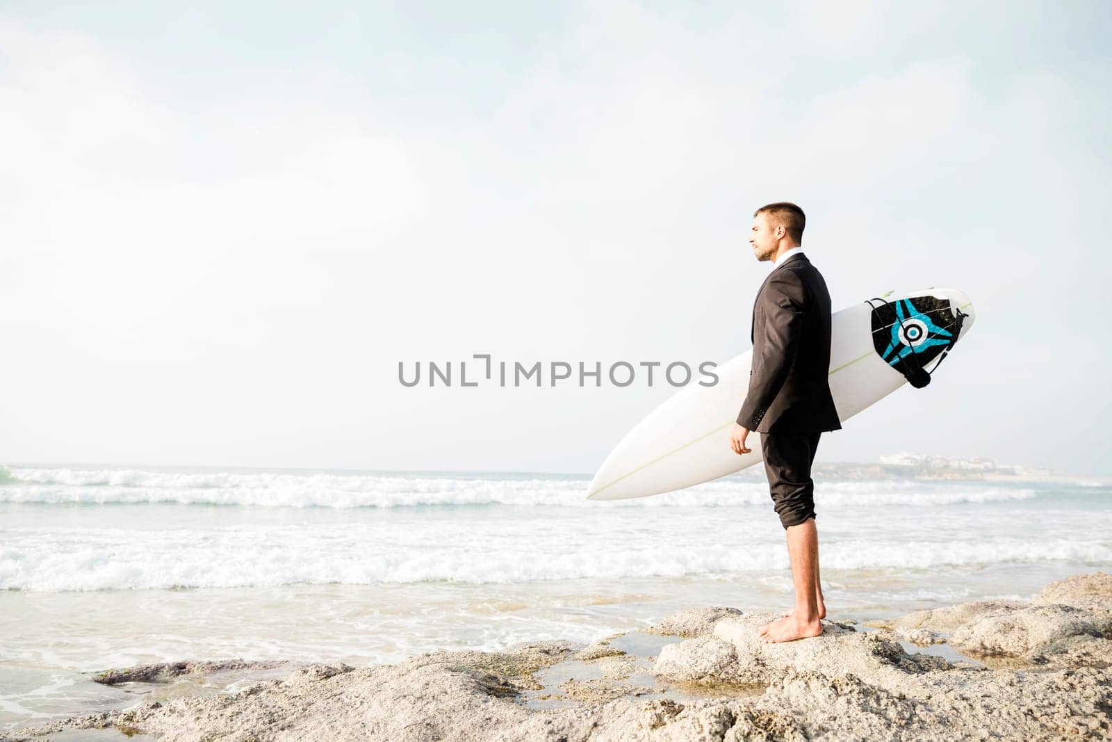 A Businessman holding is surfboard after a long day of work