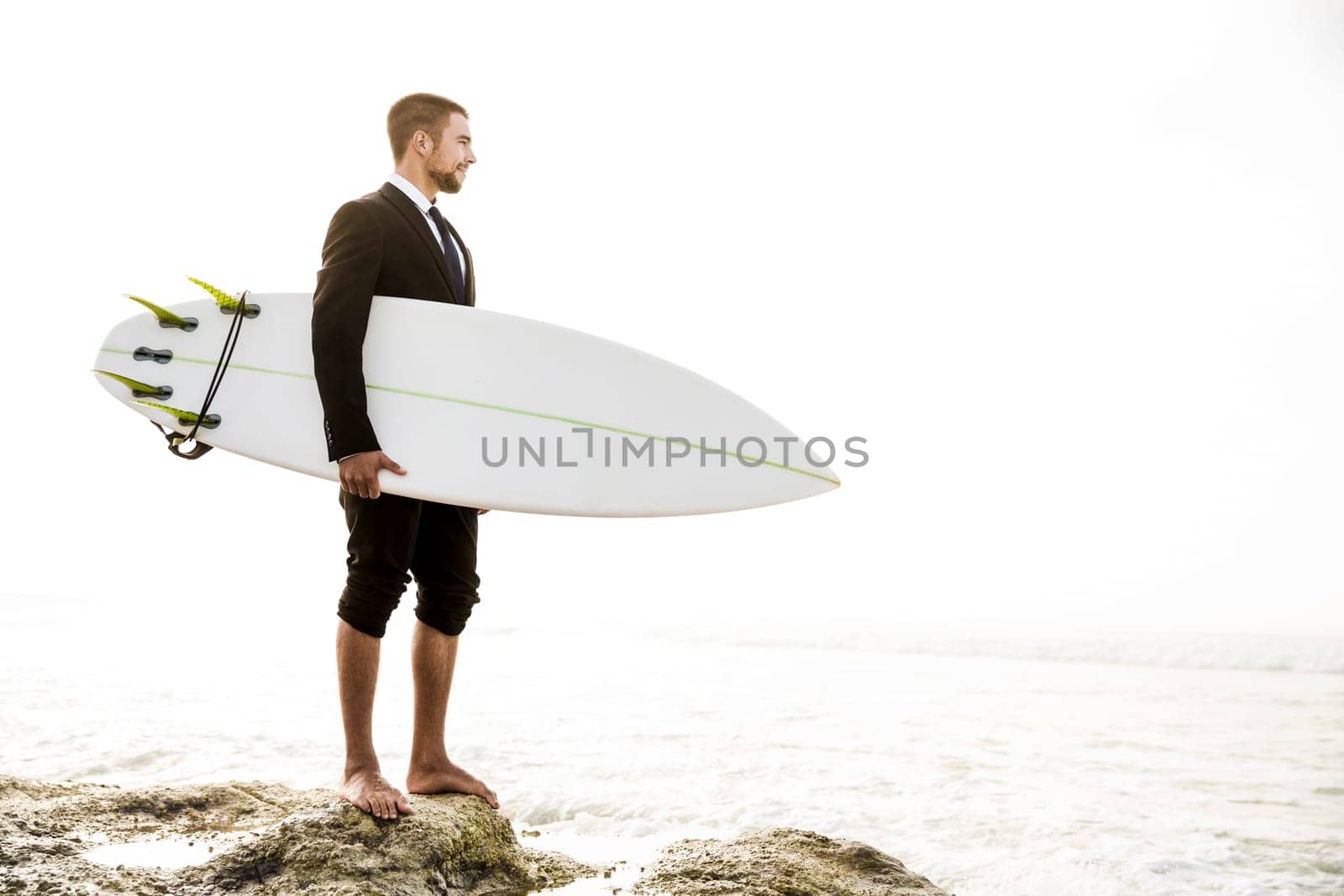 Businessman holding a chalkboard and is surfboard. Concept about a man starting a new life.