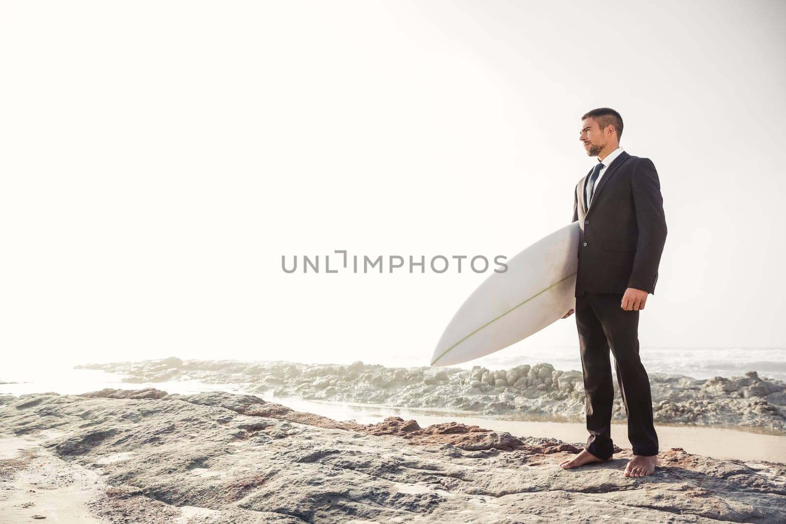 A Businessman holding is surfboard after a long day of work