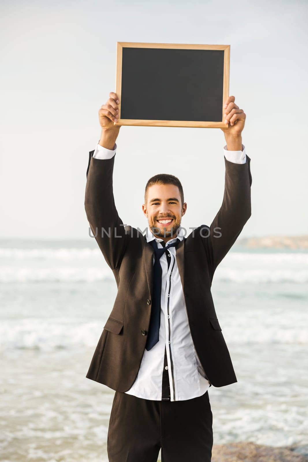 Businessman holding a chalkboard and is surfboard. Concept about a man starting a new life.