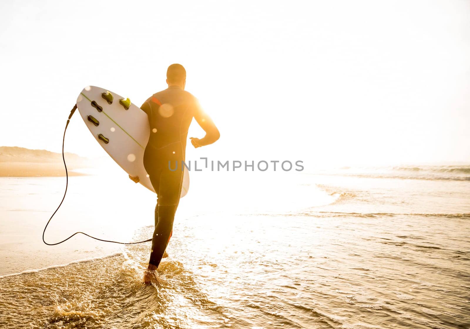 A surfer with his surfboard at the beach