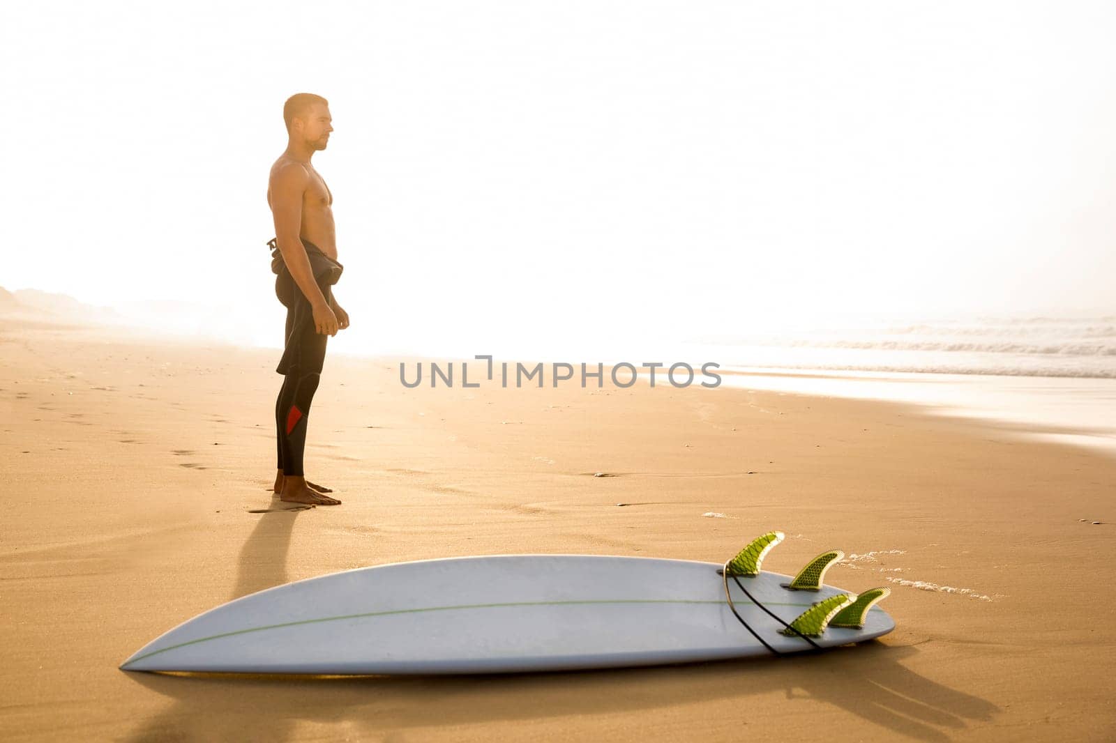 A surfer with his surfboard at the beach