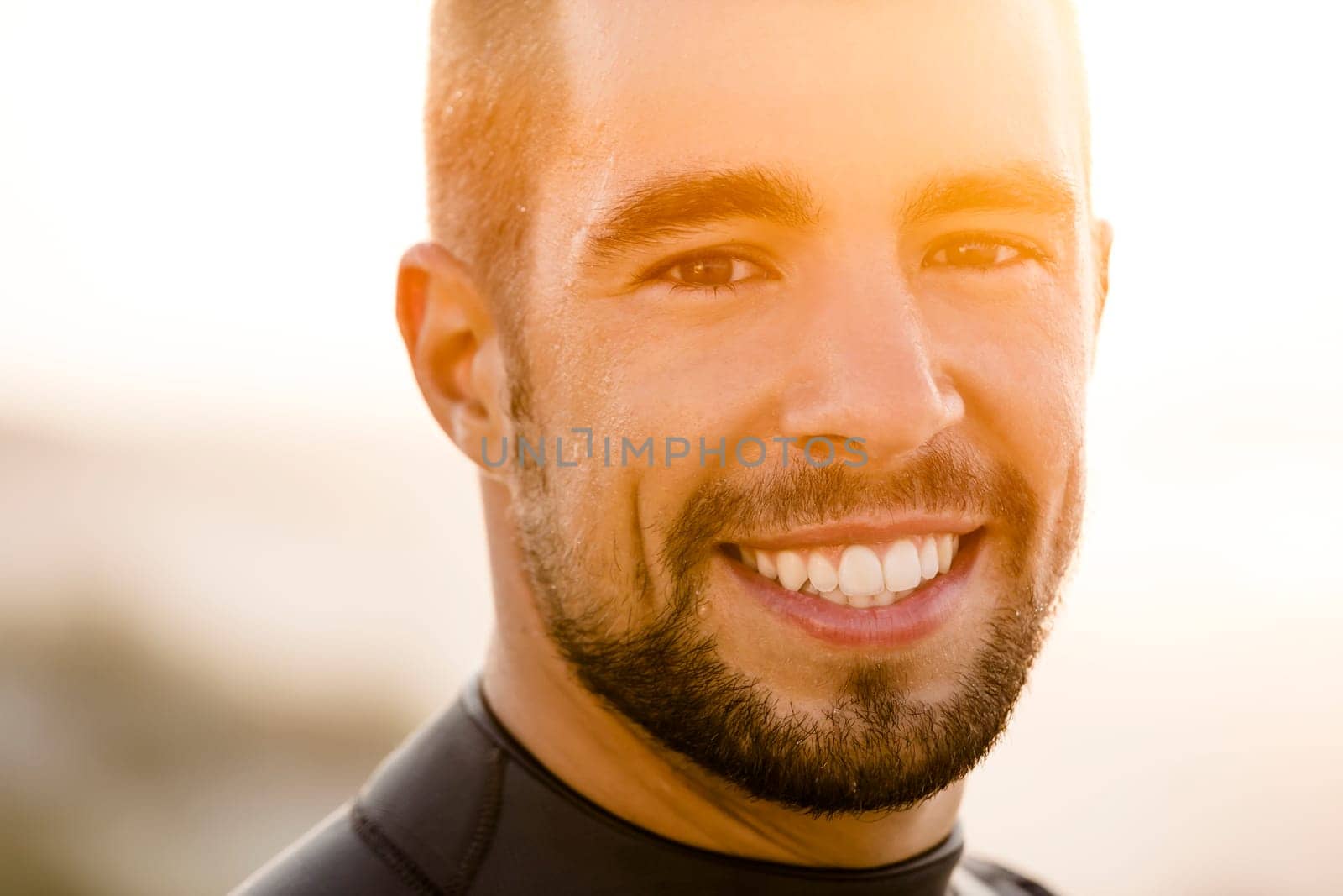 Outdoor portrait of an handsome young surfist smiling