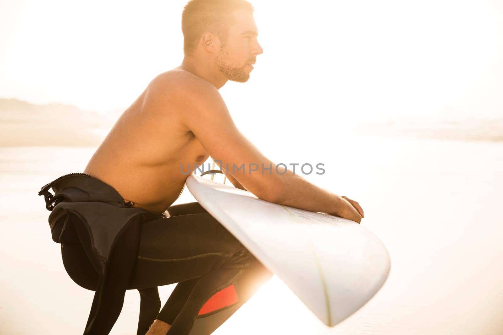A surfer with his surfboard at the beach