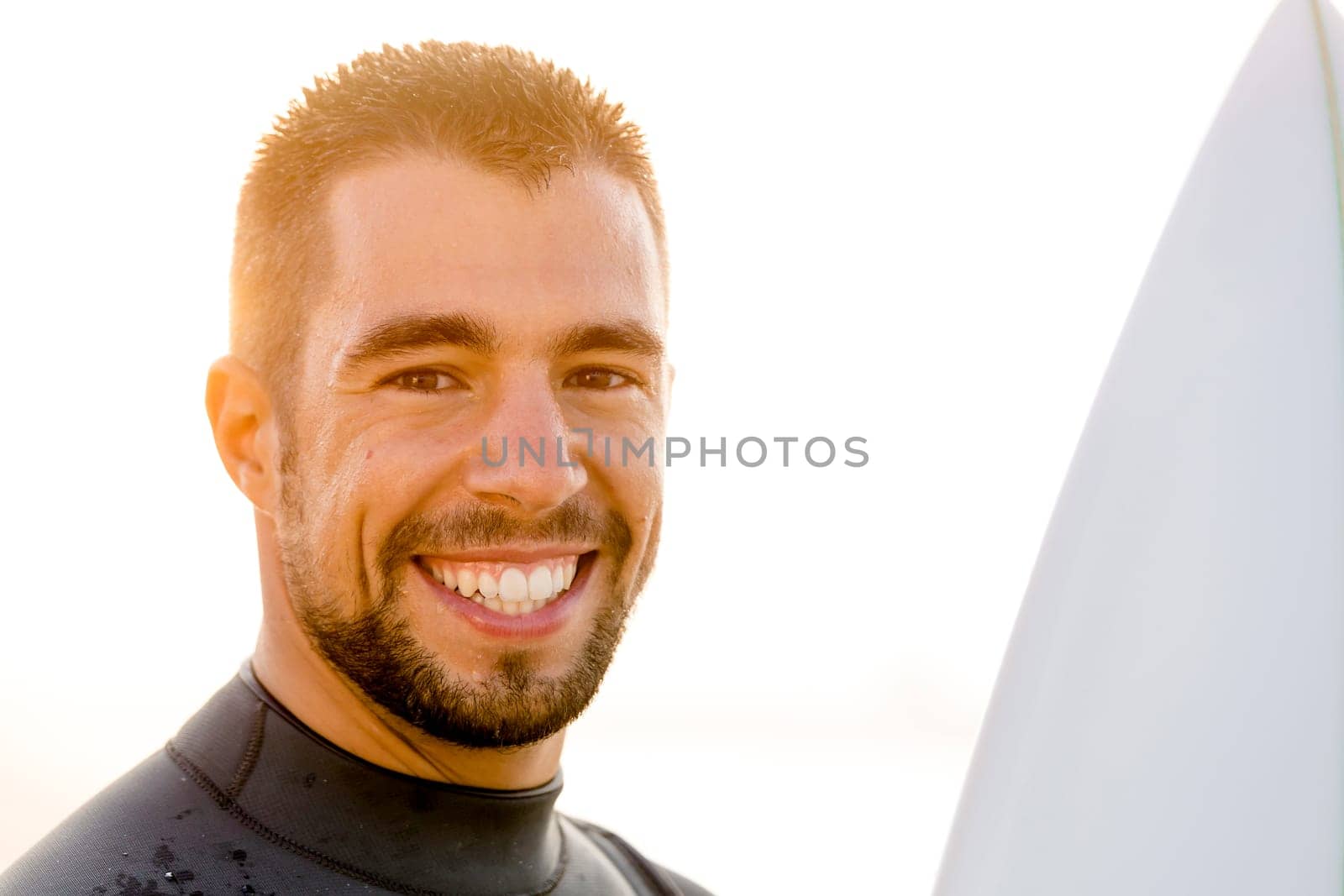 Outdoor portrait of an handsome young surfist smiling