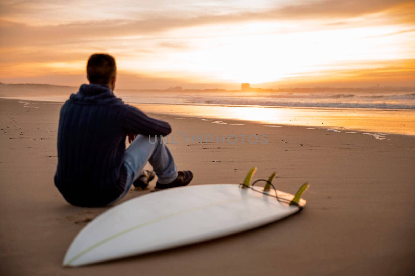 A surfer with his surfboard at the beach