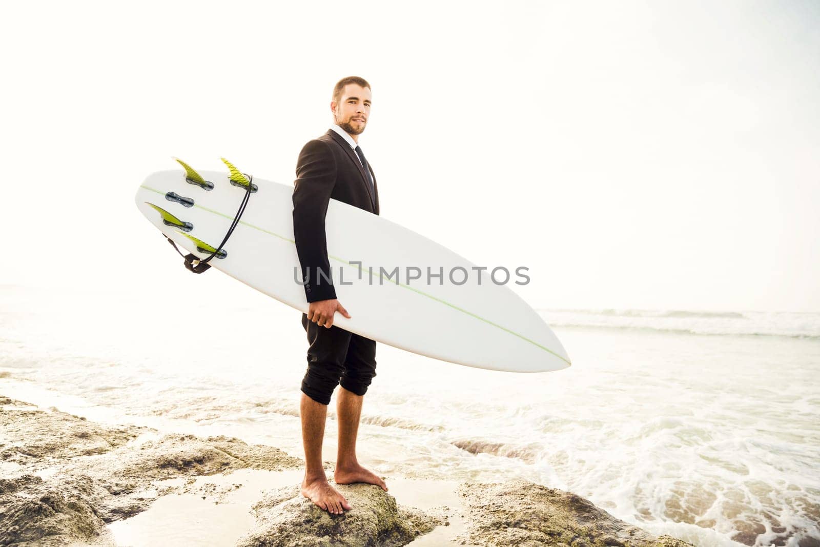 Businessman holding a chalkboard and is surfboard. Concept about a man starting a new life.
