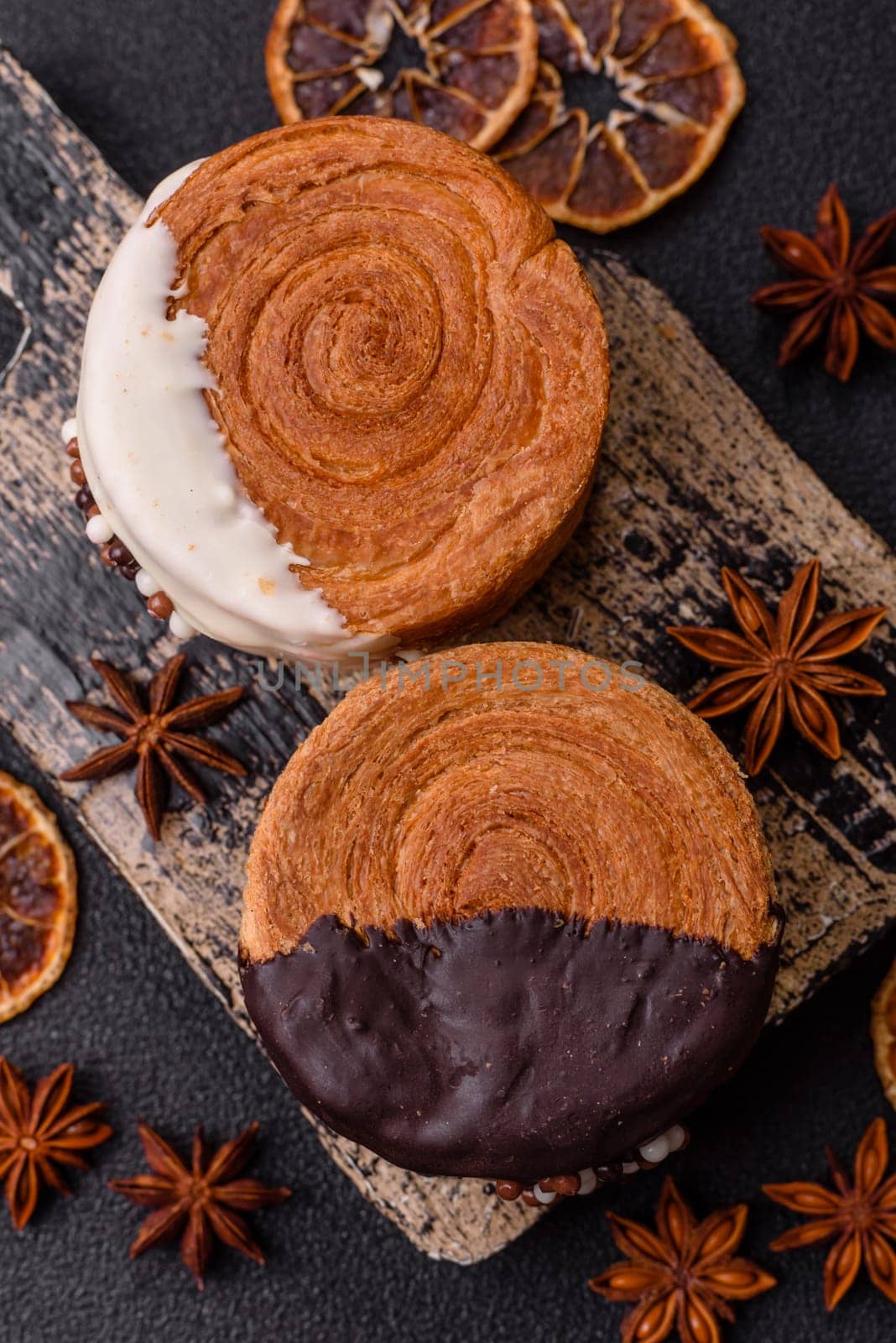 Round sweet New York roll croissant with chocolate cream filling on a dark concrete background