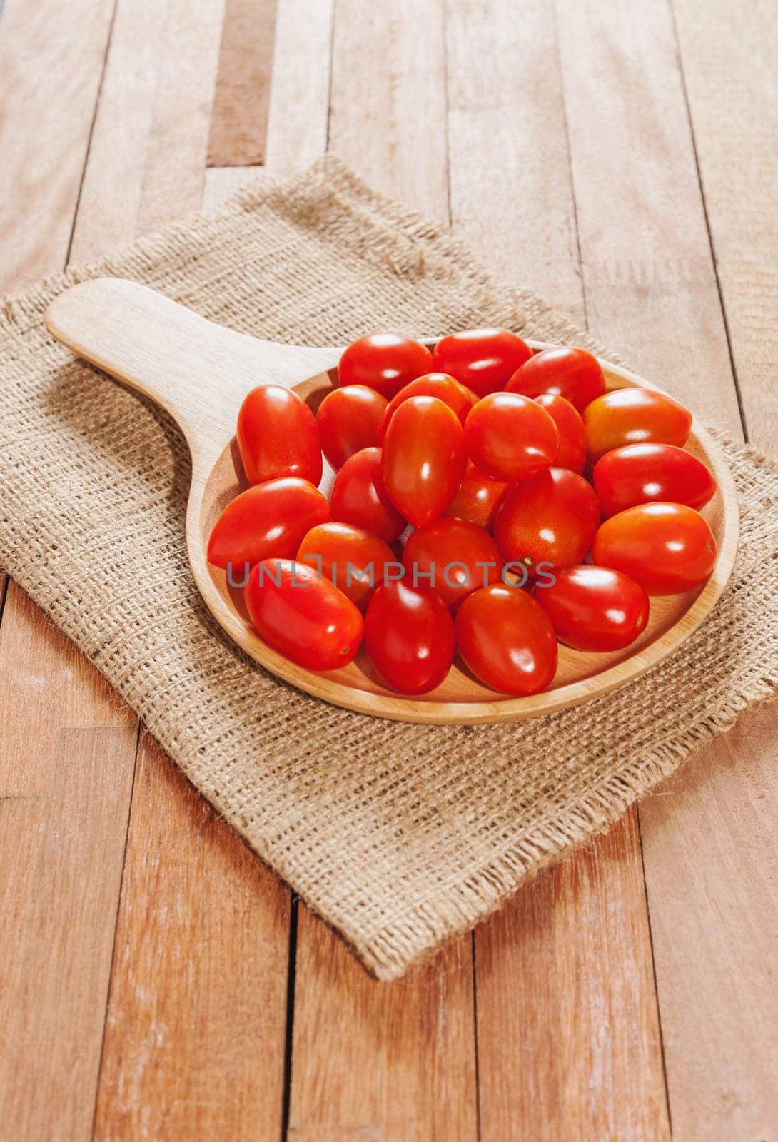 Tomato fresh in wooden bowl on wood table