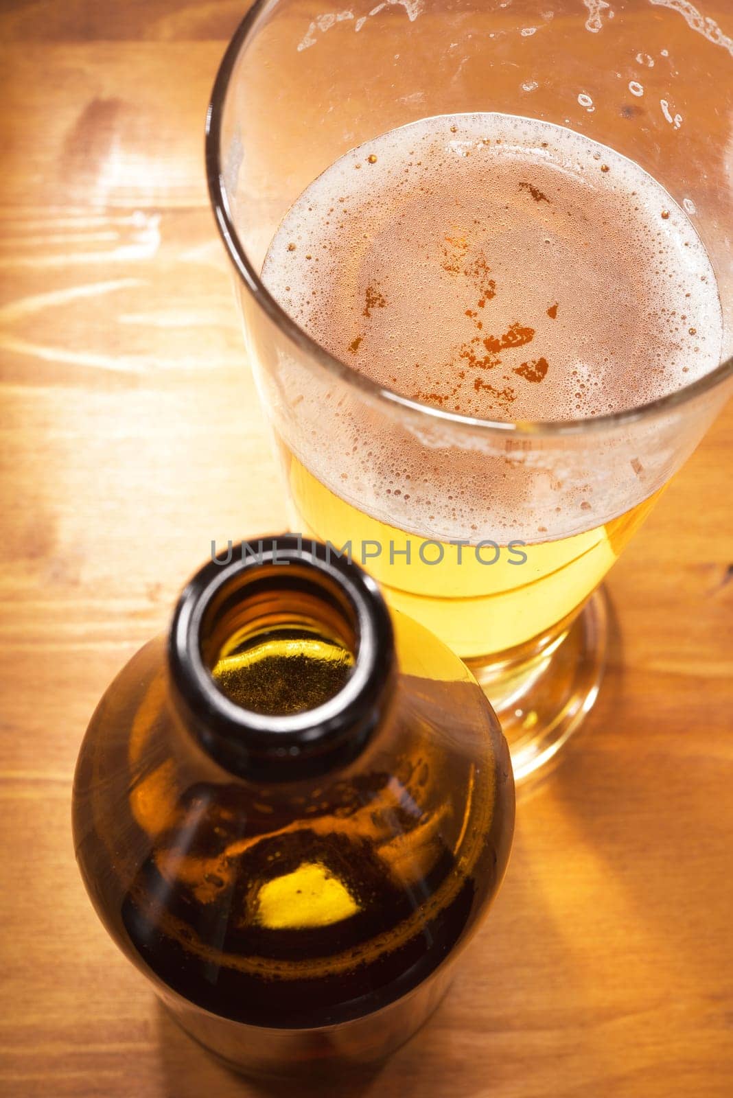 Close-up of a beer glass with beer bottle on the table