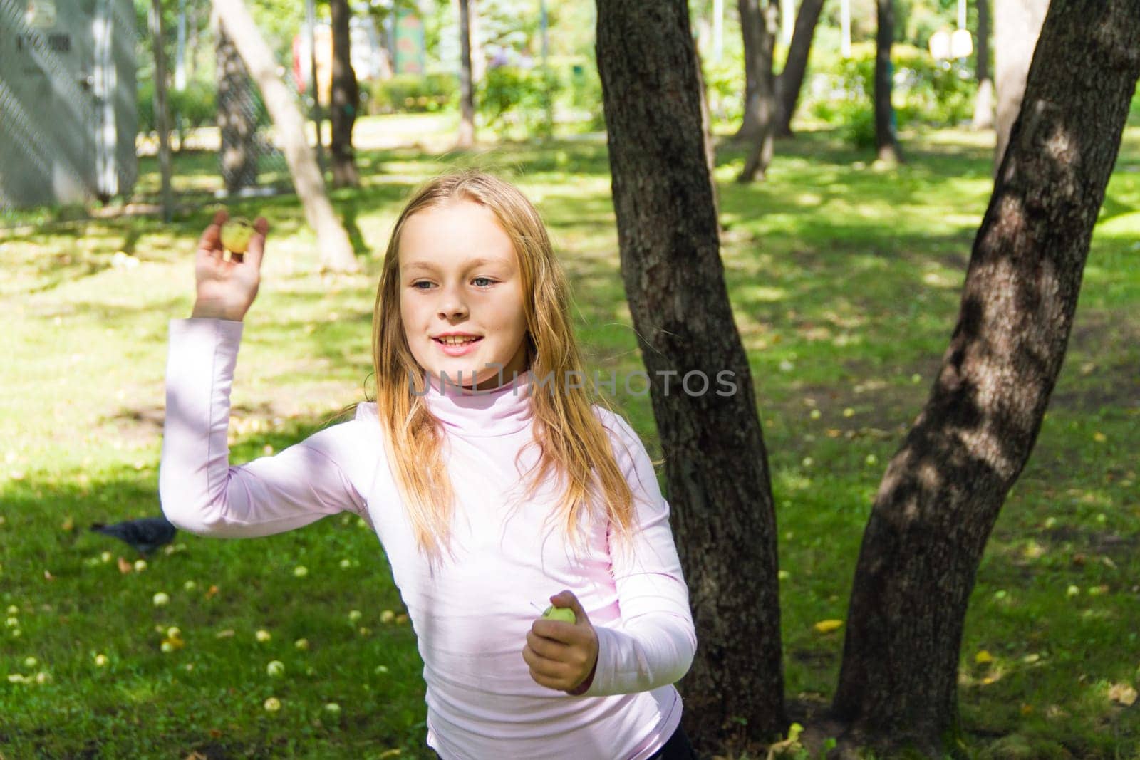 Photo of cute girl with apples in summer