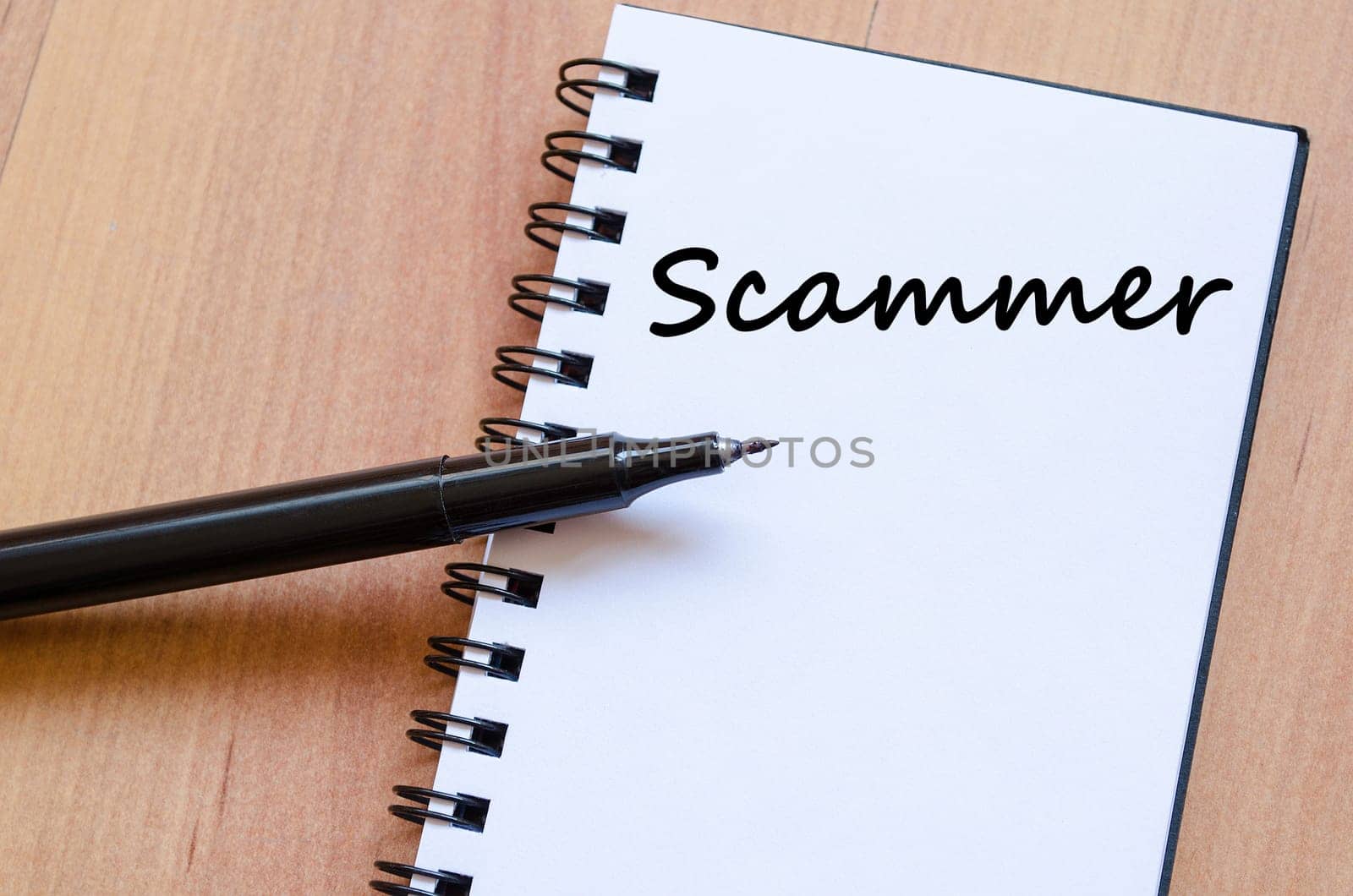 Scammer text concept write on notebook with pen