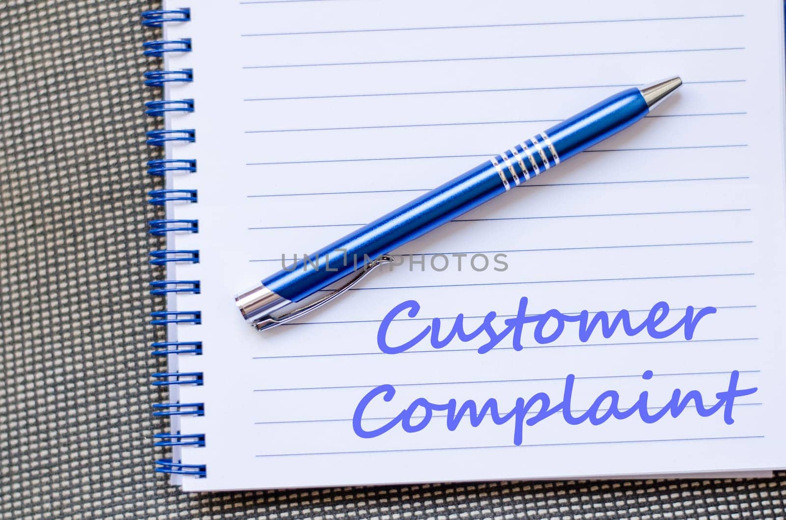 Customer complaint text concept write on notebook with pen