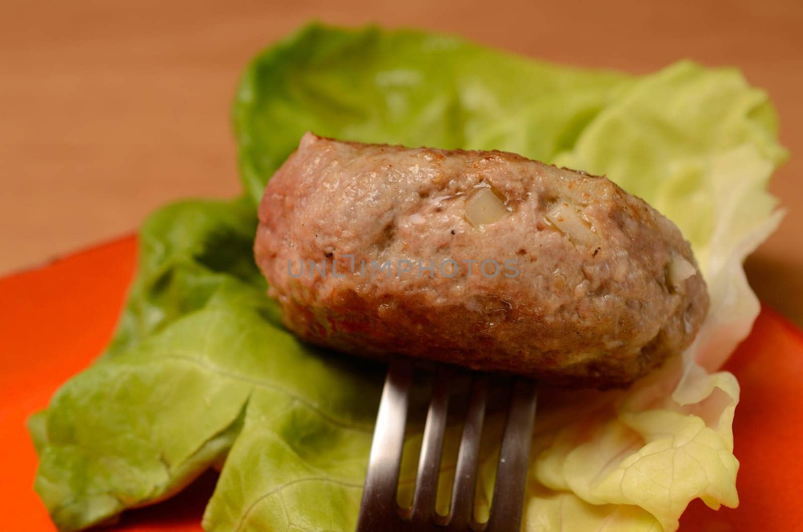 Fork with a burger and green salad