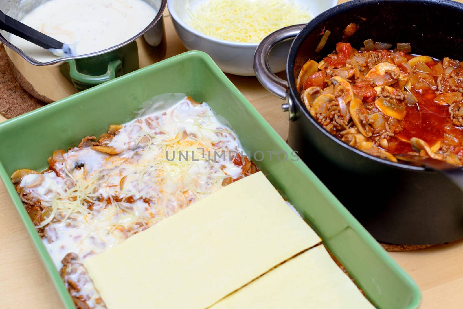preparation of lasagna in a green dish