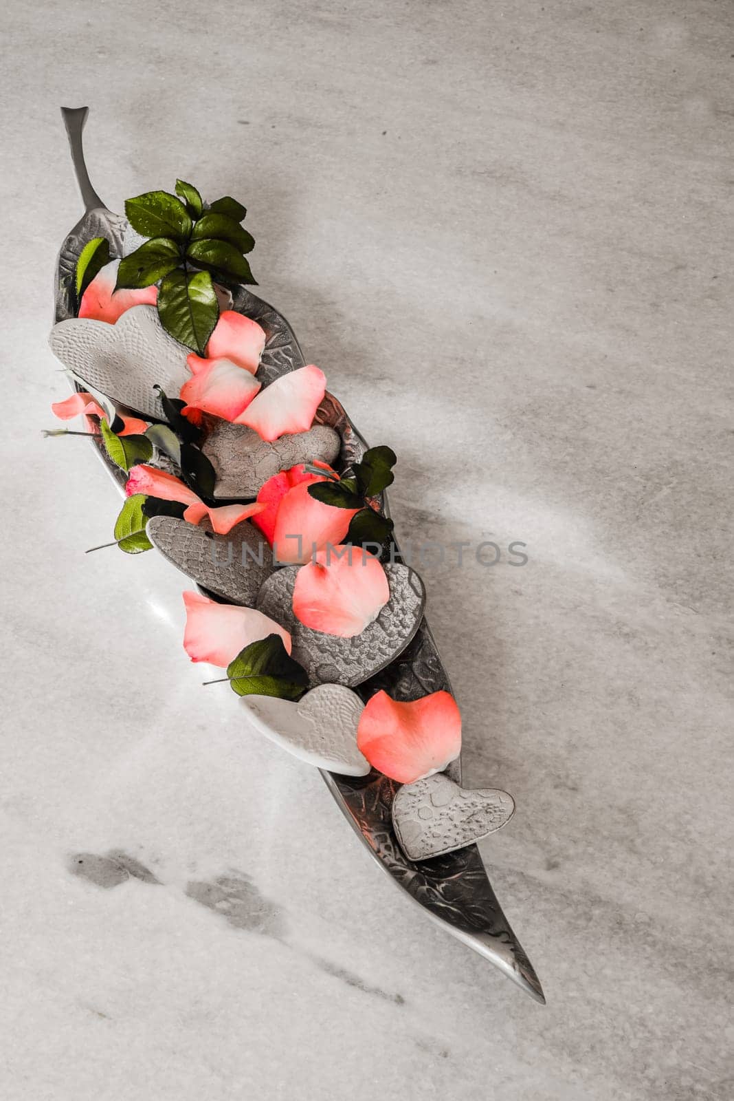 porcelain hearts and rose pebbles in a silver bowl as decoration and an offering.