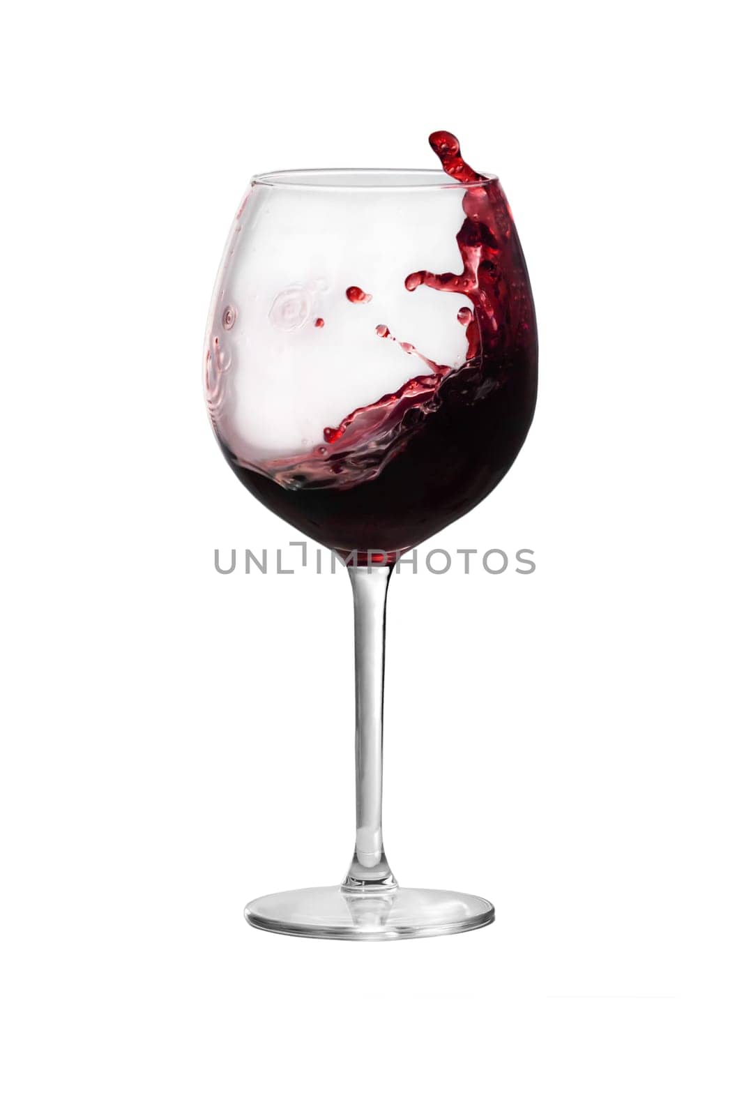 Red wine is splashing out of a wine glass