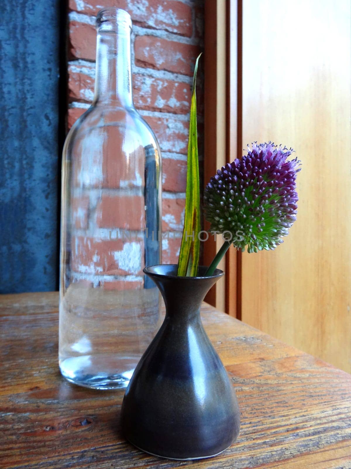 Still life of a bottle and a flower in a vase