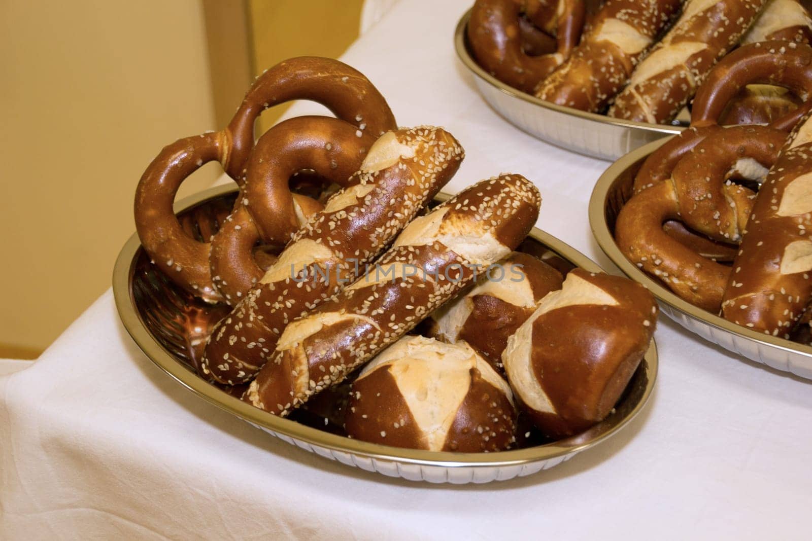 Laugen pretzels and sticks in bowls on a table with white tablecloth